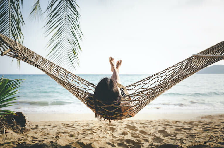 Frau entspannt in einer Hängematte am Strand
